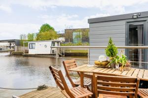 兹瓦茨勒伊斯Cozy Houseboat in Zwartsluis的房屋设有1个带桌椅的甲板