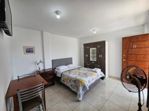 伊察Hospedaje Las Parraz的一间卧室配有一张床、一张桌子和一把椅子