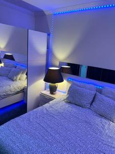 布鲁塞尔Rise Lodge的一间卧室配有一张蓝色灯光的大床