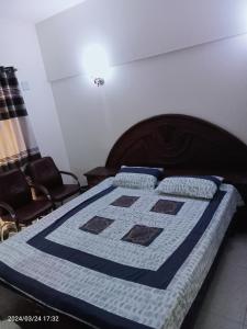 卡拉奇One Bed Furnished Apartment的床上有蓝色和白色的被子