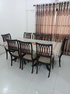 卡拉奇One Bed Furnished Apartment的餐桌和椅子以及窗帘