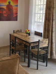 内罗毕Novel 1-Bedroom in Madaraka Estate, Nairobi的客厅配有一张木桌和椅子