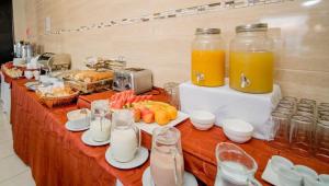 伊基克HOTEL GAVINA EXPRESS IQUIQUE的自助餐,包括橙汁和餐桌上的食品