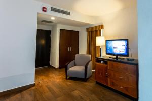 坦皮科HS HOTSSON Smart Value Tampico的酒店客房带电视和椅子