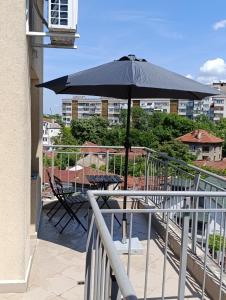 鲁塞Витски的阳台上配有带雨伞的桌子