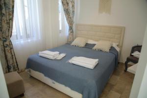 阿拉恰特Apaz Alaçatı Hotel的一间卧室配有带毛巾的床