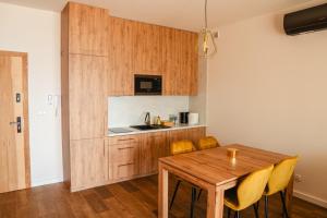Boszkowo-LetniskoBoszkowo Horizon Park的厨房以及带木桌和椅子的用餐室。