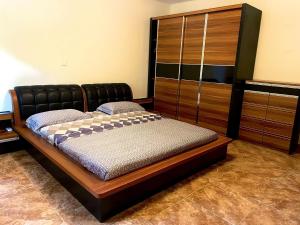 卢班戈Mapunda House的一间卧室配有一张床和一个木制橱柜