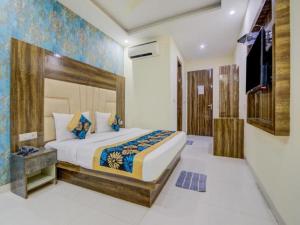 新德里Hotel ALVAA GRAND Near Delhi Airport BY-AERO HOME STAY的一间卧室配有一张大床和电视