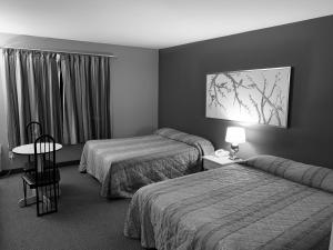 Saint ComeHôtel Saint-Côme的酒店客房设有两张床和一张桌子。