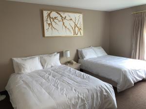 Saint ComeHôtel Saint-Côme的配有白色床单的酒店客房内的两张床