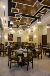 埃莫西约Hotel Santorian的用餐室设有桌椅和木制天花板
