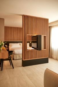 圣地亚哥Lastarria Hotel的酒店客房,设有床铺和墙上的电视