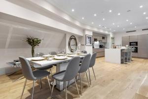 伦敦Park Lane Palace- Luxury Sleeps 10的厨房以及带桌椅的用餐室。