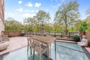 伦敦Park Lane Palace- Luxury Sleeps 10的一个带桌椅的庭院和一个游泳池
