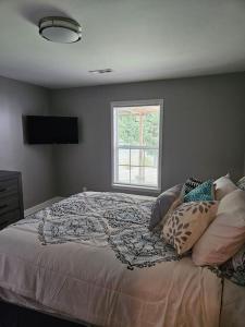 格林斯伯勒Maro's Paradise的卧室配有带枕头的床铺和窗户。