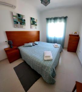 阿尔图拉Apartamento Sunrise的一间卧室配有一张床,上面有两条毛巾