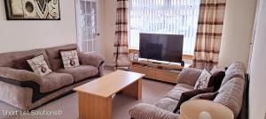 塞顿港Curlew - Port Seton的带沙发和平面电视的客厅