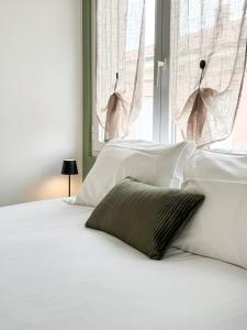 博尔迪盖拉Casa Febo, in centro con parcheggio privato a 200 mt dal mare的一张带白色床单和绿色枕头的床