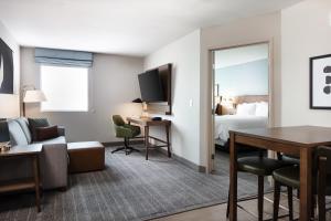 克拉尔维尔Staybridge Suites - Iowa City - Coralville, an IHG Hotel的酒店客房设有床和客厅。