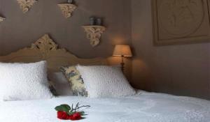蒙尼肯丹品质住宿酒店的一间卧室配有一张白色床,上面有红花