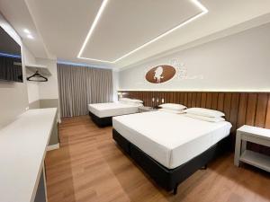 加斯帕Fazzenda Park Resort的酒店客房配有两张床和一张书桌