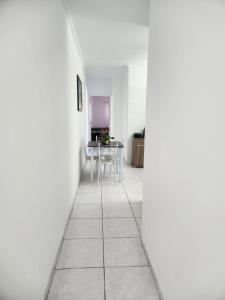 保罗阿方索城Excelente apartamento centro Paulo Afonso的走廊设有白色的墙壁和桌椅