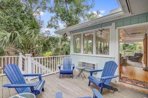 棕榈岛Twin Oaks Cottage 26的一个带3把蓝色椅子和桌子的门廊