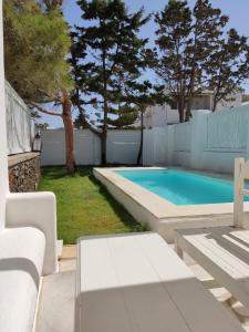 帕罗奇亚Rodi Apartments的后院的游泳池,有白色的围栏