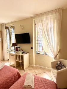 圣雷莫Camere Chicca的一间卧室配有一张床、一张书桌和一个窗户。