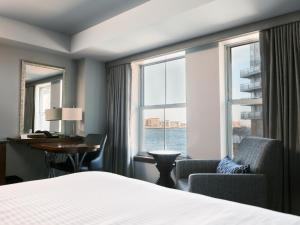 波士顿波士顿滨水区巴特利码头酒店的配有一张床、一张书桌和一扇窗户的酒店客房