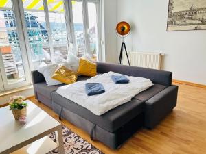德累斯顿STARiVA - modernes Terrassen Apartment - Duplex Garage - Netflix的客厅配有带枕头的沙发