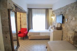 伊兹密尔Filizce Alaçatı的酒店客房,配有一张床和一张红色椅子