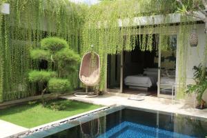 金巴兰Vlad Bali Villa的一座花园,花园旁设有游泳池
