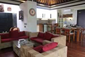 金巴兰Vlad Bali Villa的带沙发和红色枕头的客厅