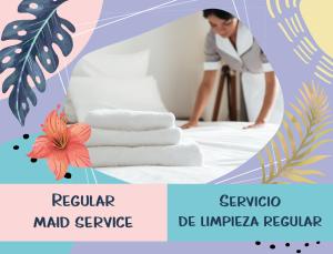 蓬塔卡纳DUCASSI Suites ROOMS & BEACH - playa Bavaro - WiFi - Parking - ROOFTOP POOL & SPA 的一位女性在带毛巾的房间里整理床铺