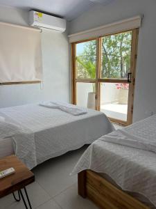 托卢Mykonos Beach House的带窗户的客房内的两张床