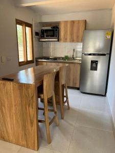 托卢Mykonos Beach House的厨房配有木桌和冰箱。
