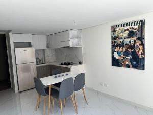 巴兰基亚Apartamento nuevo amoblado的厨房配有桌椅和墙上的绘画作品