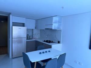 巴兰基亚Apartamento nuevo amoblado的厨房配有白色橱柜和桌椅