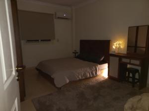 开罗Joe Excellence Residence的一间卧室配有一张床、梳妆台和书桌