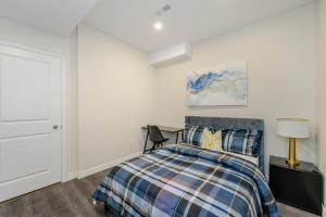 奥克维尔Private basement bedrooms in Oakville的一间卧室配有一张床和一张带台灯的书桌