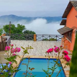 瓜拉米兰加Belaninha的一座房子前方的游泳池,上面有粉红色的花朵