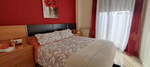 特伦普Ca l'Esmolet的一间卧室设有一张床和红色的墙壁
