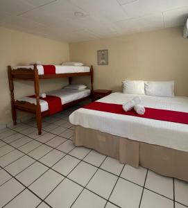 南圣胡安Hotel Ocean View的客房设有两张床和一张双层床。