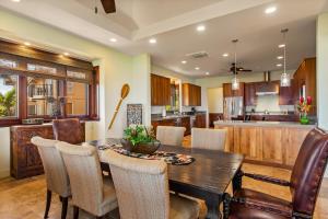 KipuHalana Malie - Ocean Views的厨房以及带木桌和椅子的用餐室。