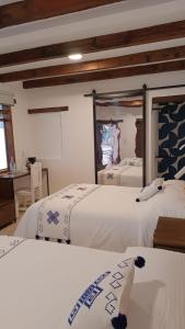 圣克里斯托瓦尔-德拉斯卡萨斯Hotel Ocho Barrios的一间卧室配有两张床和镜子