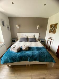 特雷西索梅La Villa Mirabelle 2min d'Arromanches-les-Bains的一间卧室配有一张带蓝色毯子的大床