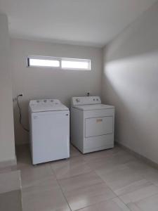 蒙特雷Alojamiento Entero Monterrey Airport的一间房间,里面配有两个洗衣机和烘干机