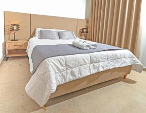 麦德林Apartamentos Montecarlo的一间卧室配有一张大床和两条毛巾